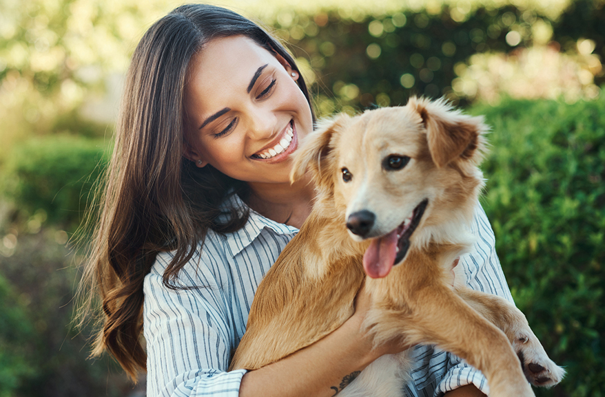 Happy woman cuddling a small dog