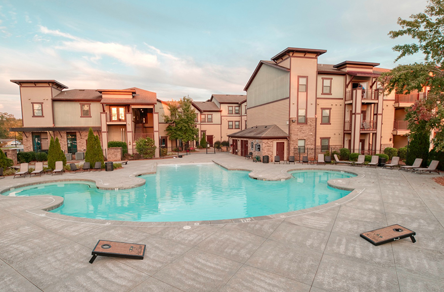 View of the pool with the apartment building in the background.