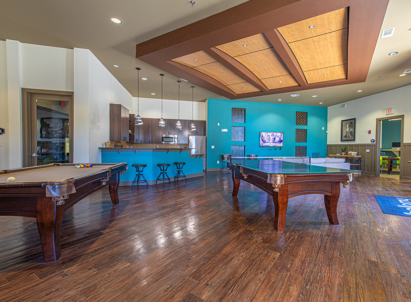 Club room with counter and stools, and pool tables.