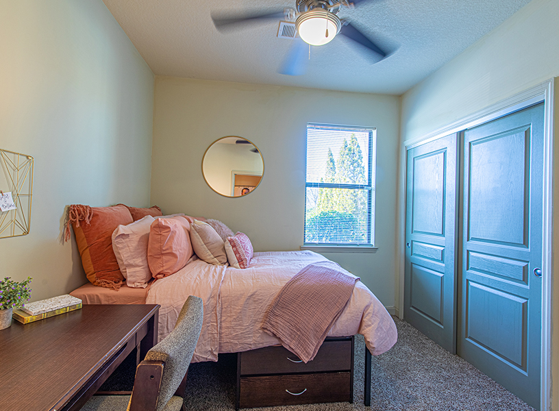 Bedroom with a bed made with pink bedsheets